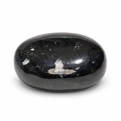 Ergonomic curved Black Tourmaline soap bar resting in open palm demonstrating comfortable grip for bath and shower