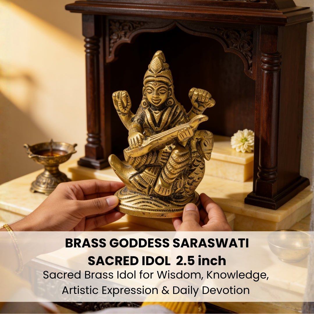 Brass Saraswati statue placed on a wooden study table beside open notebooks, peacock feather, brass diya, and fresh flowers
