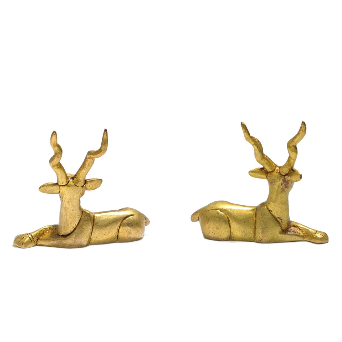 Detailed close-up of polished solid brass texture highlighting finely carved antlers, facial expressions, and smooth curved flanks