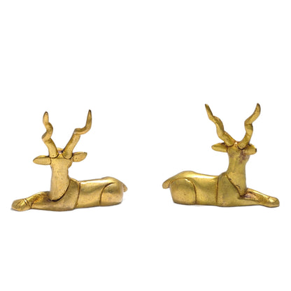 Detailed close-up of polished solid brass texture highlighting finely carved antlers, facial expressions, and smooth curved flanks