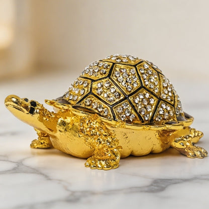 Golden Feng Shui bejeweled tortoise with crystal-studded shell on a marble surface