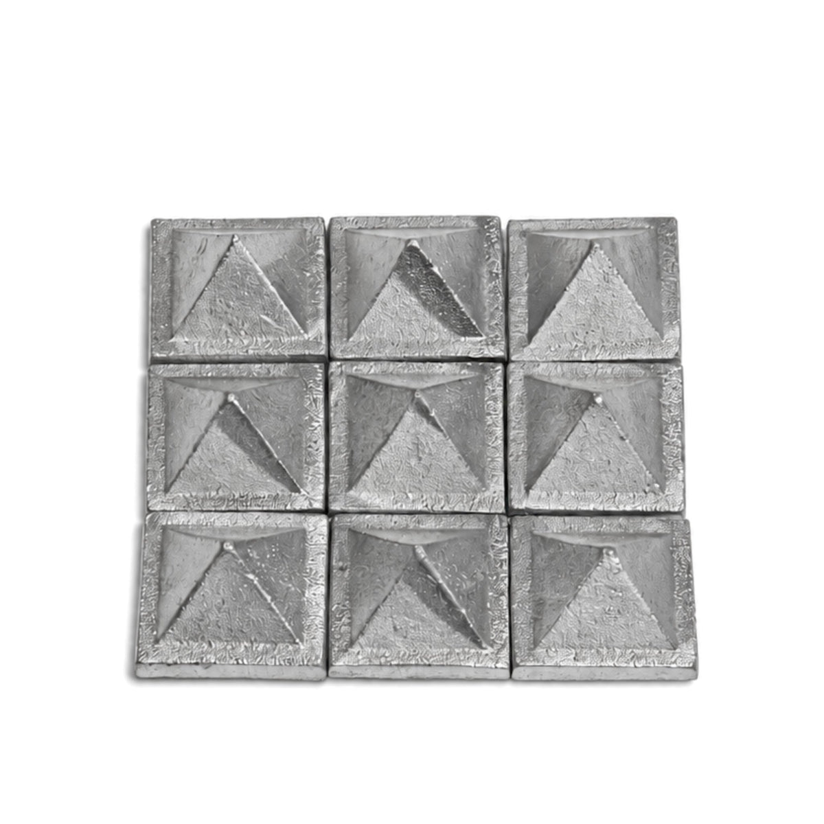 1-inch solid lead pyramid held between fingers demonstrating compact size, dense heavy metal feel, and solid build