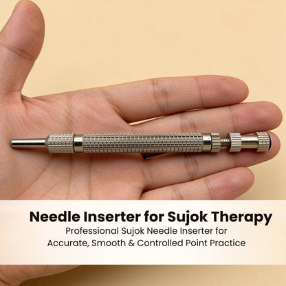 Sujok needle inserter positioned over palm acupressure point demonstrating single-click micro needle application