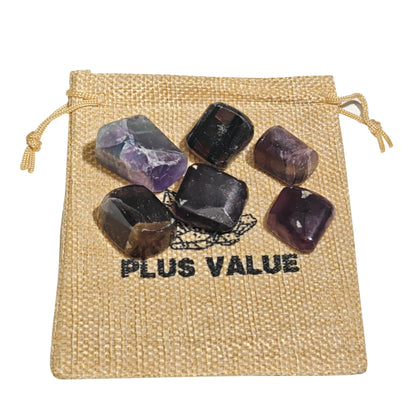 Close-up of smooth polished Purple Fluorite pebbles showing translucent violet hues, chevron banding, and glassy luster