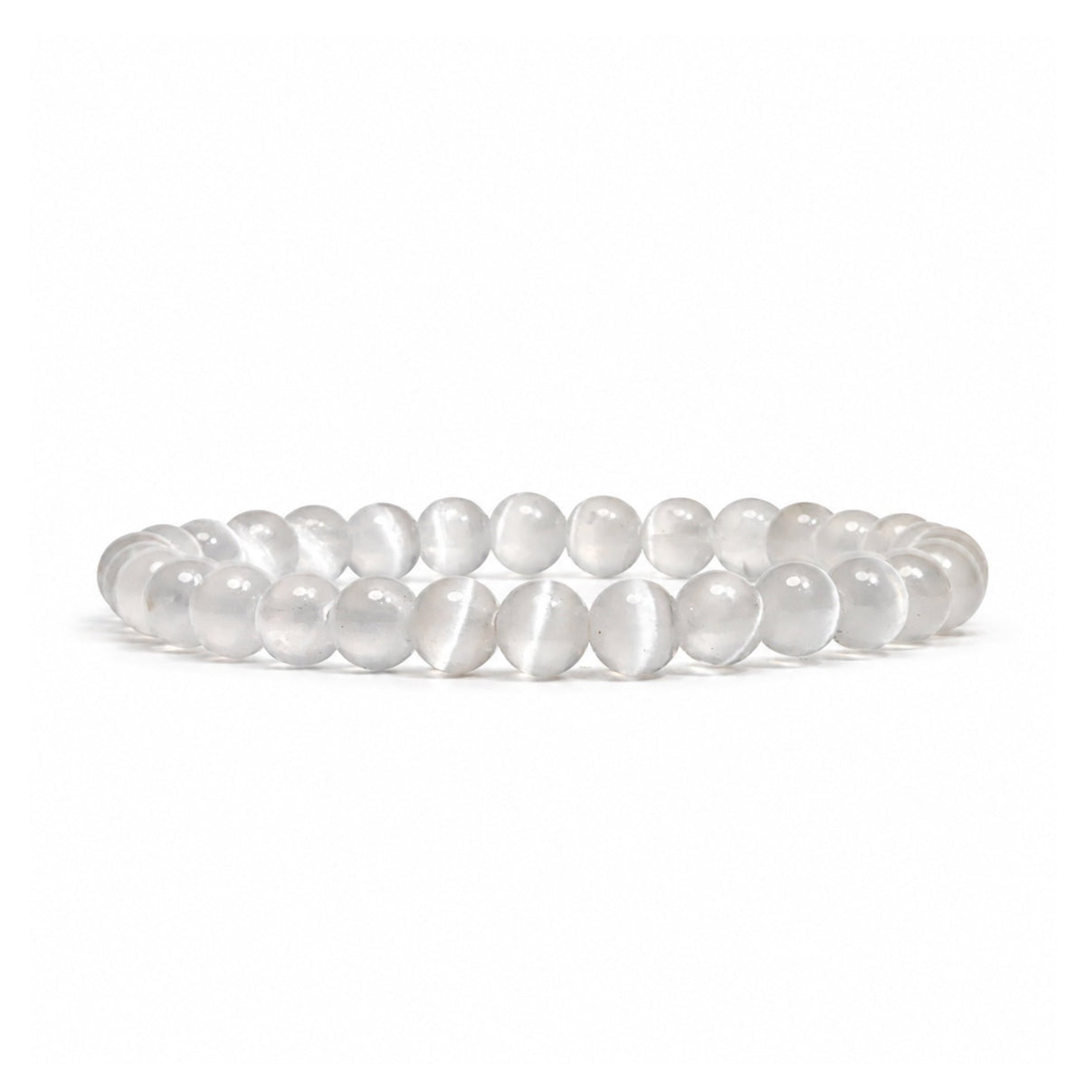 Close-up of 6 mm polished beads highlighting authentic fibrous crystal striations, milky white translucence, and pearlescent chatoyant sheen