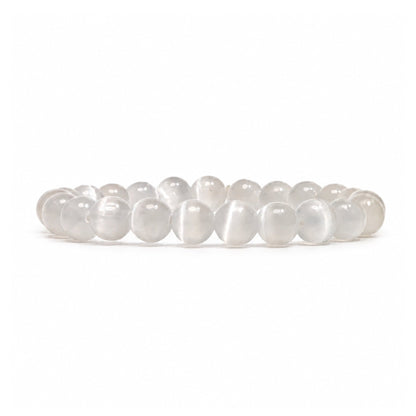 Close-up of 8 mm polished beads displaying authentic milky white translucence, fibrous crystal striations, and luminous cat-eye sheen