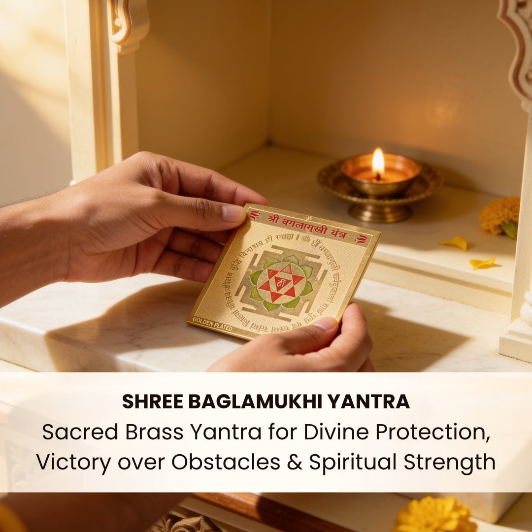 Shree Baglamukhi Yantra placed on a yellow velvet cloth in a home temple beside a brass diya, Haldi mala, and fresh yellow marigold flowers
