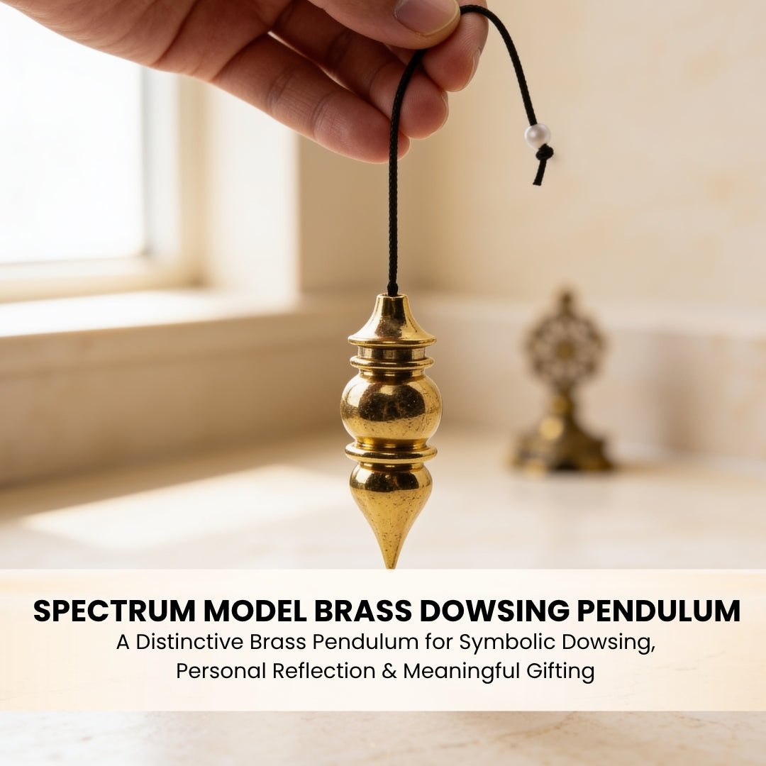 Spectrum brass pendulum suspended from fingers demonstrating ergonomic weight balance and sensitive swing