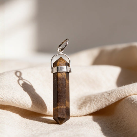natural tiger eye pencil shape pendant on a plain background