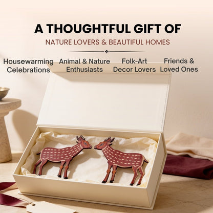 Elegant wooden deer pair styled on a living room console table beside indoor plants and books