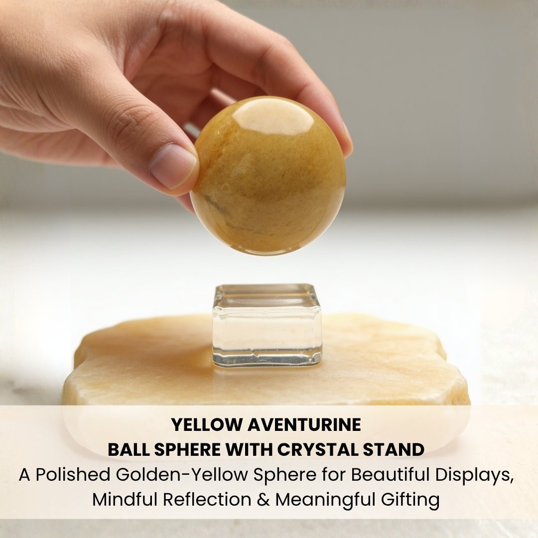 Smooth polished Yellow Aventurine sphere held in open palm showing ergonomic size and glassy gemstone polish