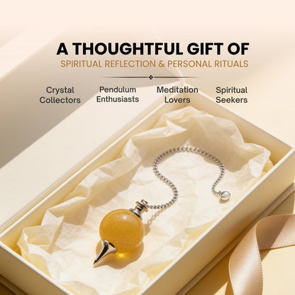 Yellow Aventurine crystal ball pendulum held by chain between fingertips demonstrating balanced weight and smooth swing
