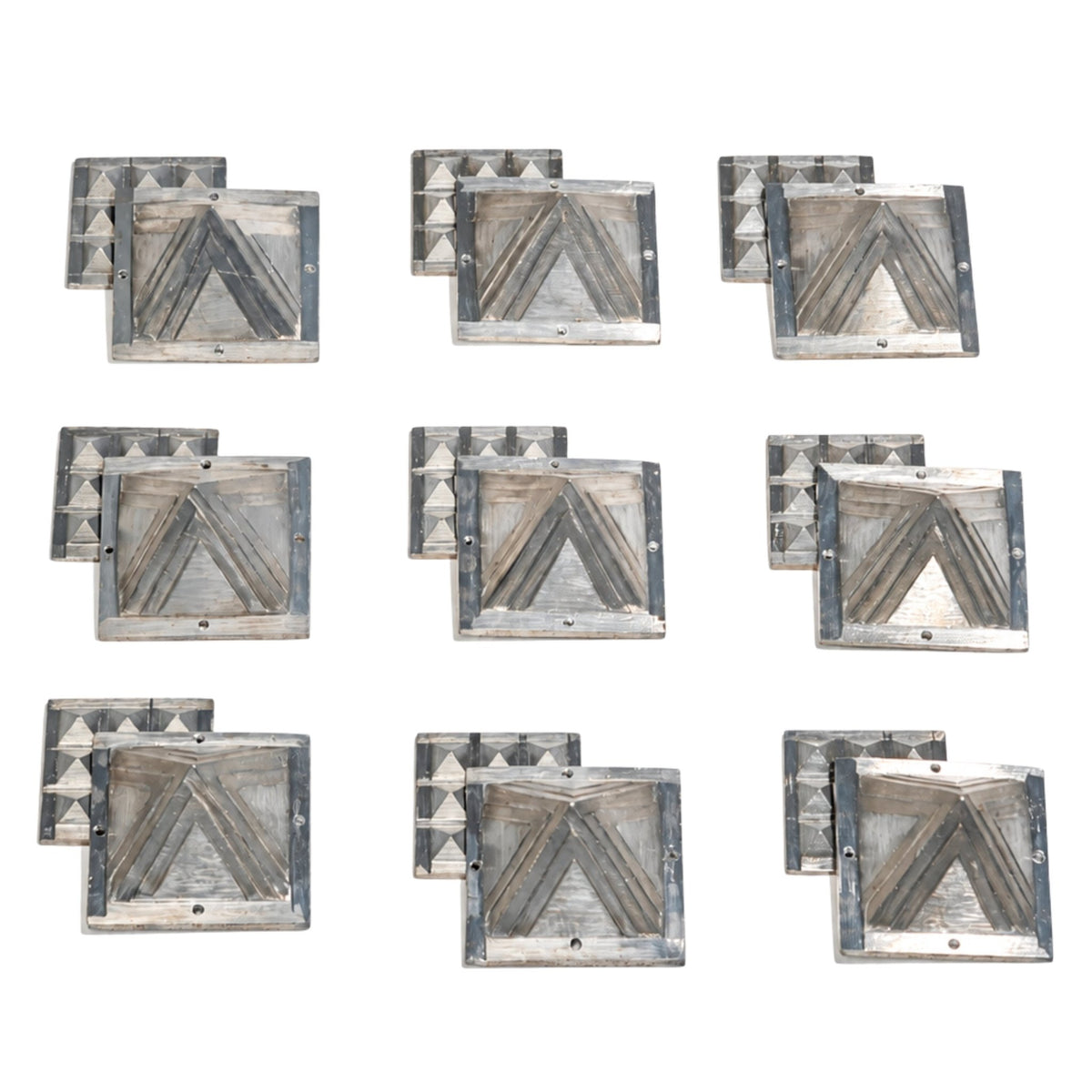 Detailed macro shot of authentic cast zinc metal surface showing silver-grey metallic sheen, angular bevels, and clean apex points