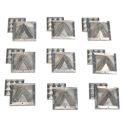 Detailed macro shot of authentic cast zinc metal surface showing silver-grey metallic sheen, angular bevels, and clean apex points